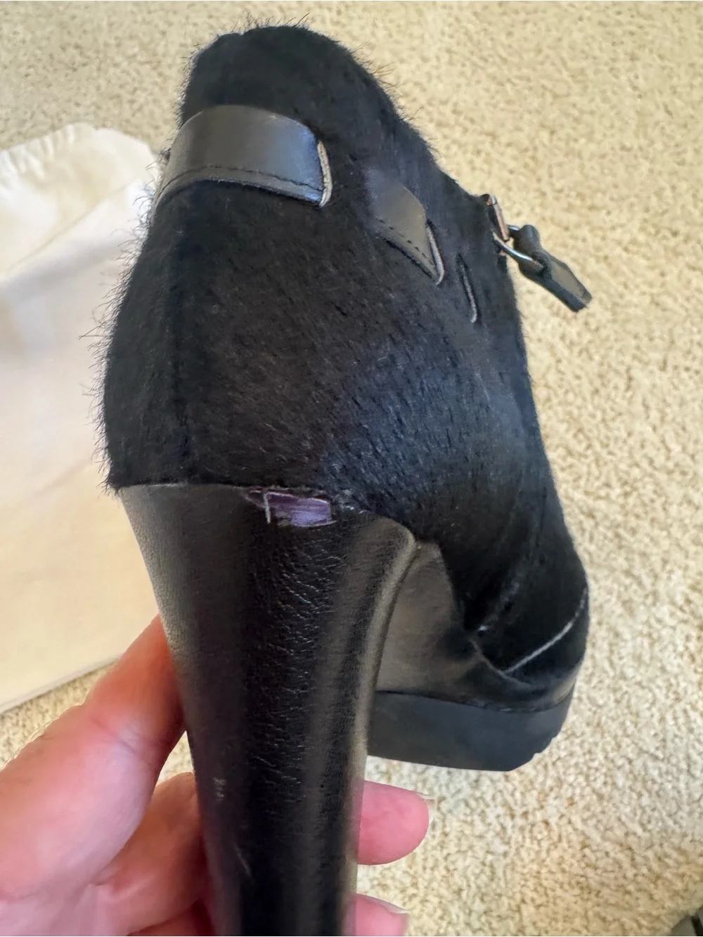 ZORAIDE black calf hair ankle booties with leather strap and tassel accents.